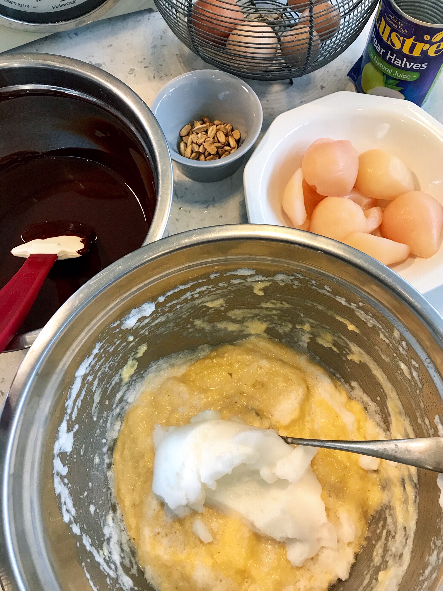 Flourless chocolate and pear cake being made with ingredients on a table.