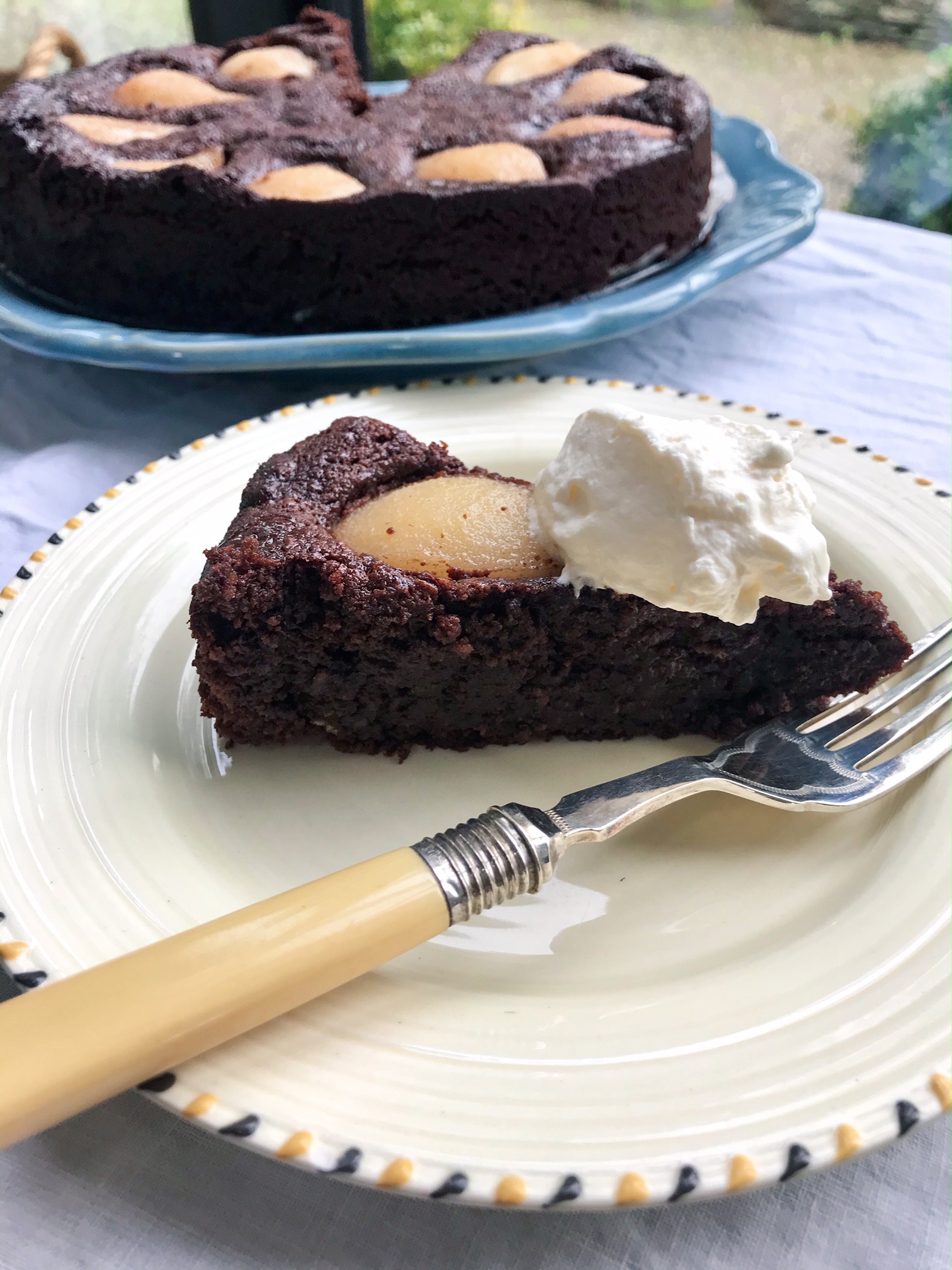 Flourless chocolate and pear cake with cardamon syrup on a plate.