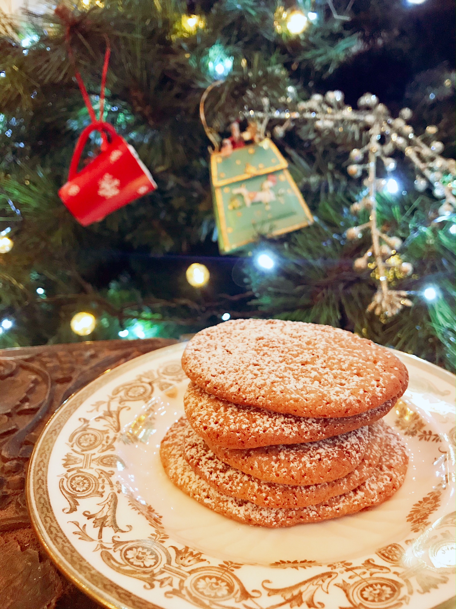 Christmas crunch cookies on a plate with a christmas tree behind.