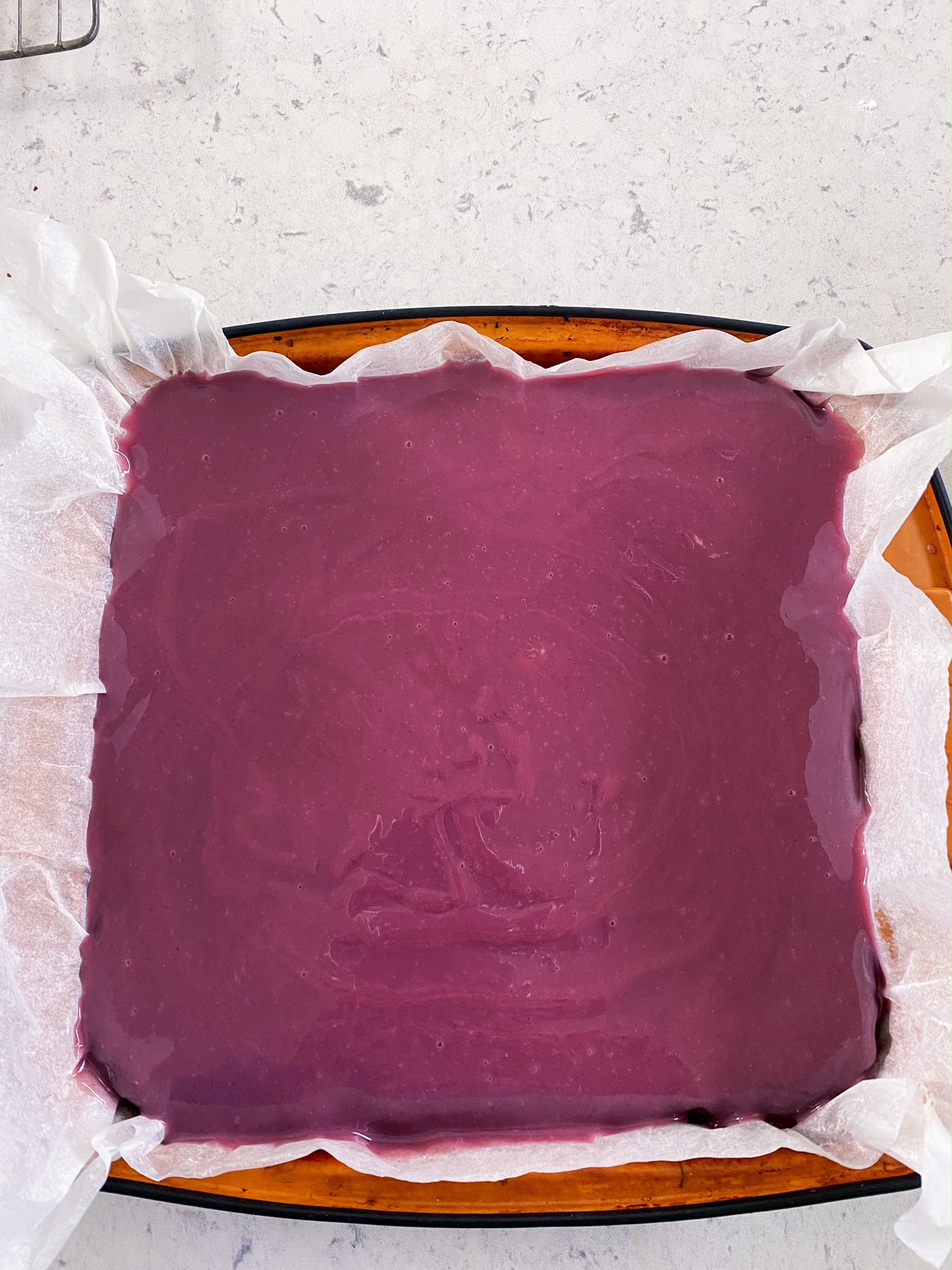 White Chocolate Berry Ganache Brownies in a cake tin.