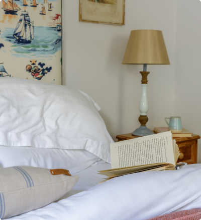 Cozy bed wit ha book on top.