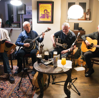 Four musicians playing instruments indoors.