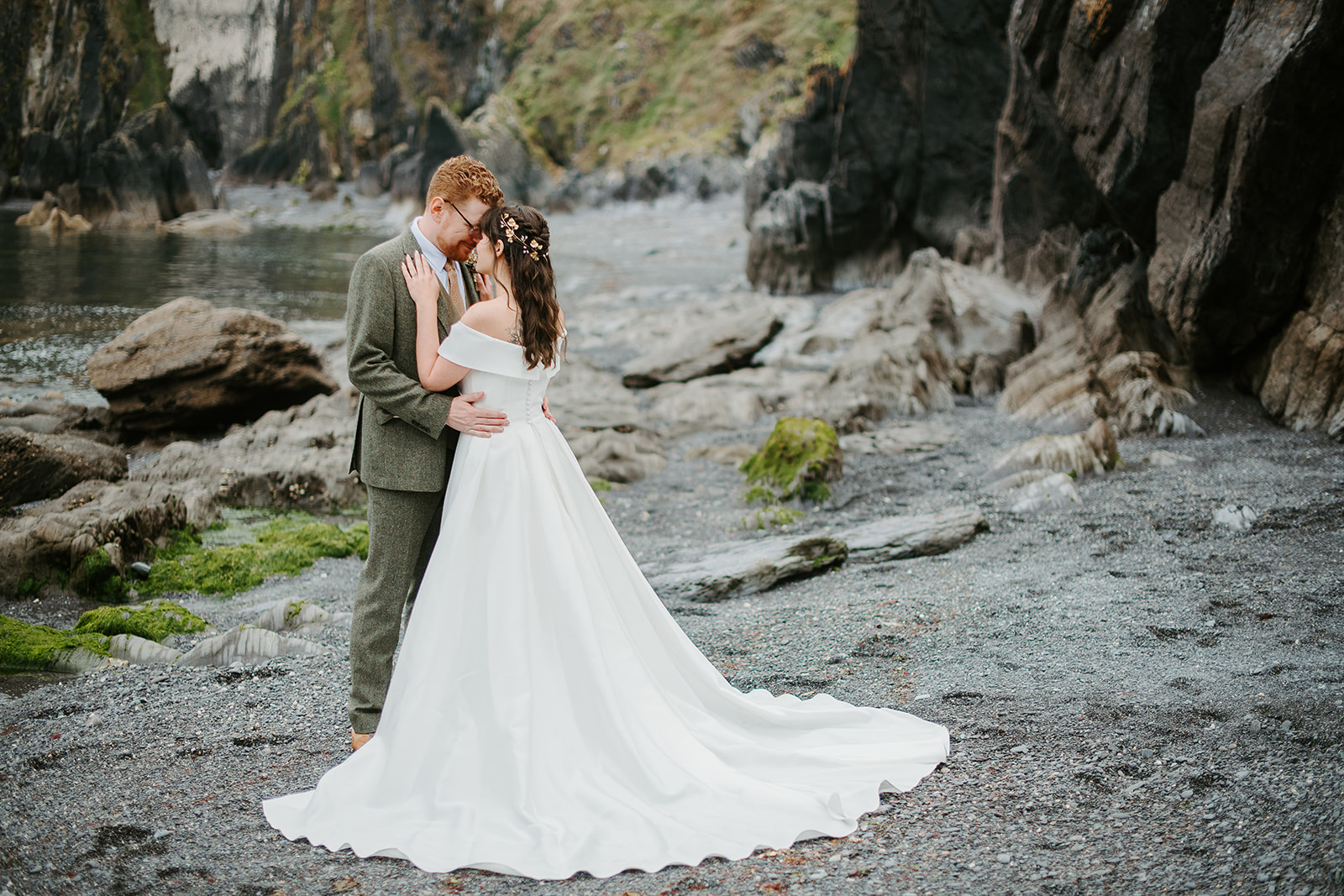 Wedding couple hugging by a lake.