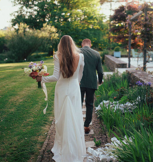 Wedding couple walking down a sidewalk.