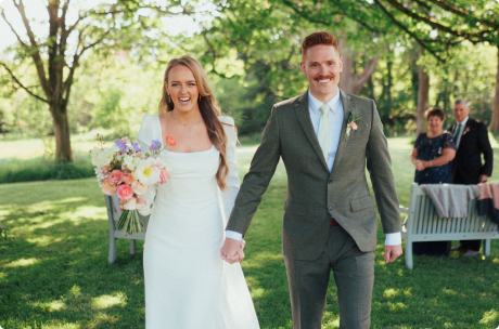 Wedding couple smiling and holding hands.