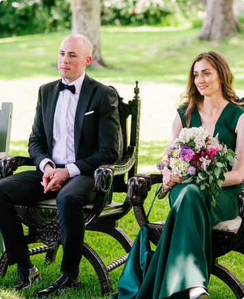 Wedding couple sitting on a chair. bride holds flowers.