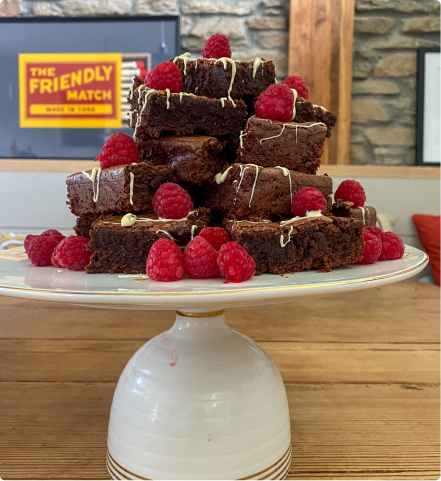 Chocolate raspberry brownies on a glass plate.