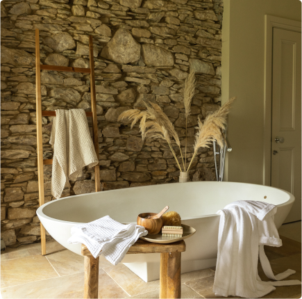 Bathtub with a stone wall behind.