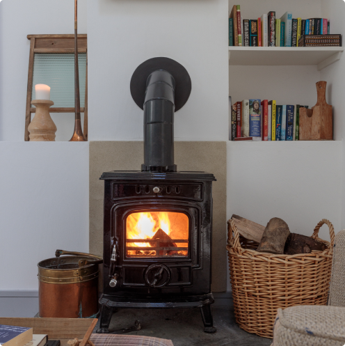 Dunowen stove lit on fire with wood on the side.