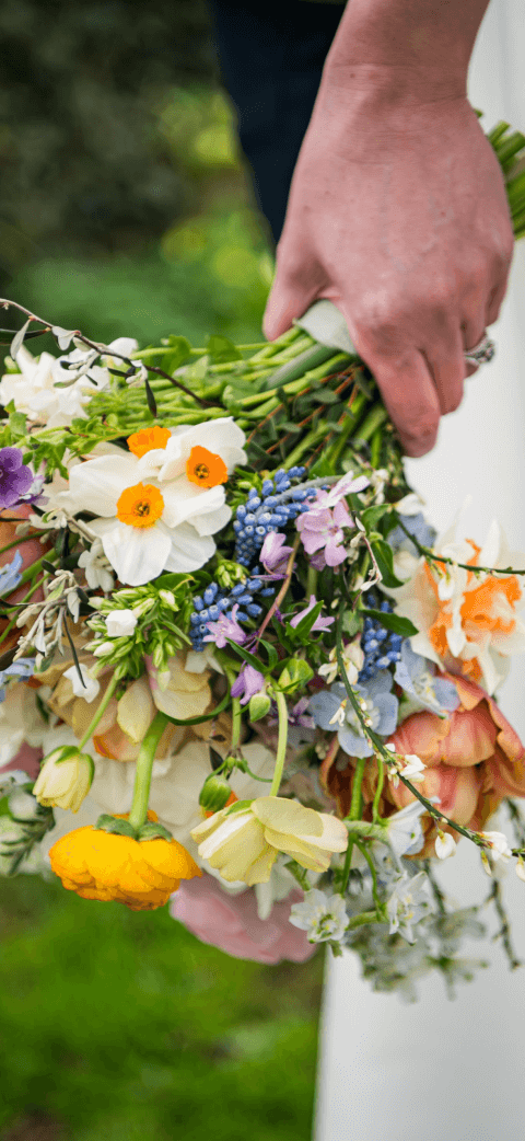 Wedding image closeup brides hand holding flowers.
