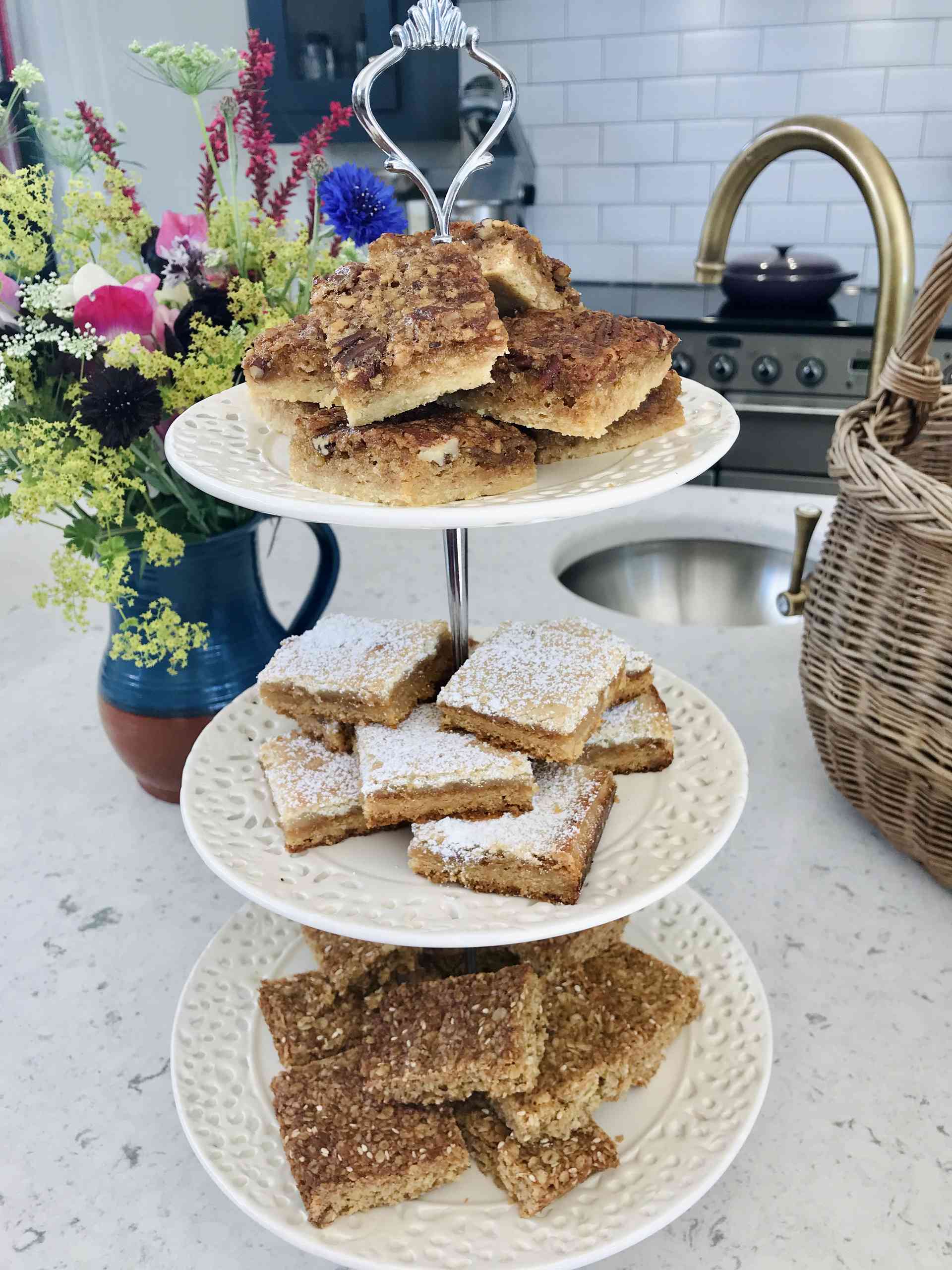 Tray bakes on a tiered plating arrangement for afternoon tea.