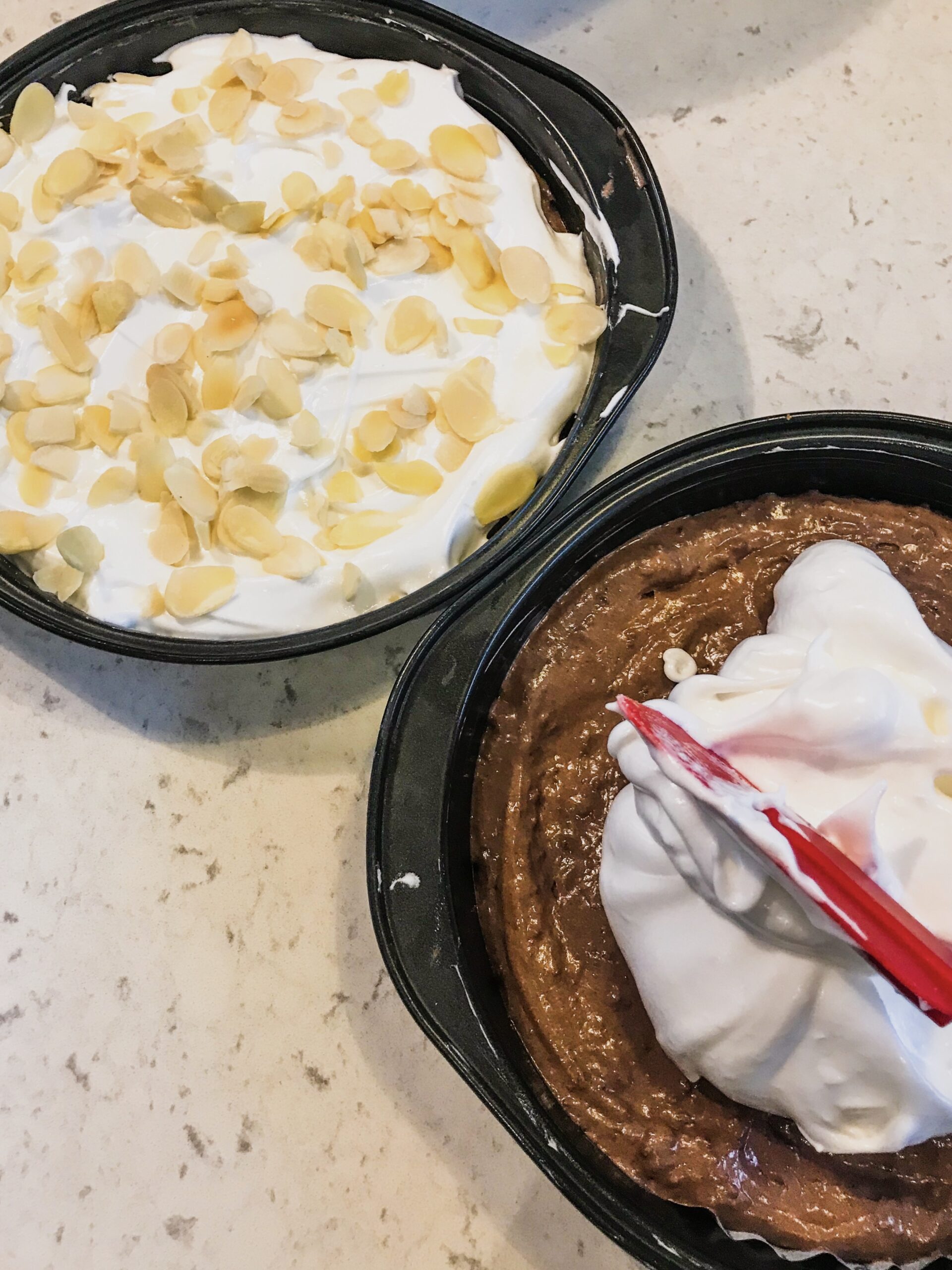 Chocolate and meringue layer cake in the making on a kitchen countertop.