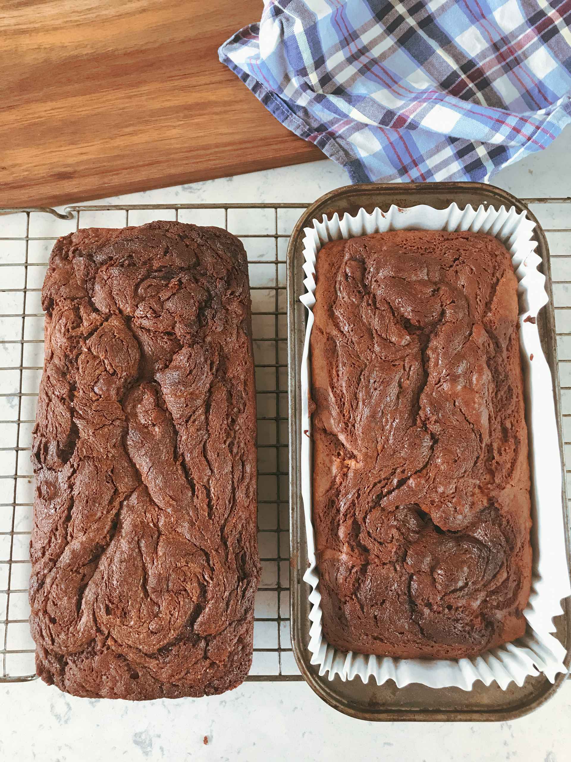 Banana and Nutella swirl bread, one on a rack the other in a cake pan.