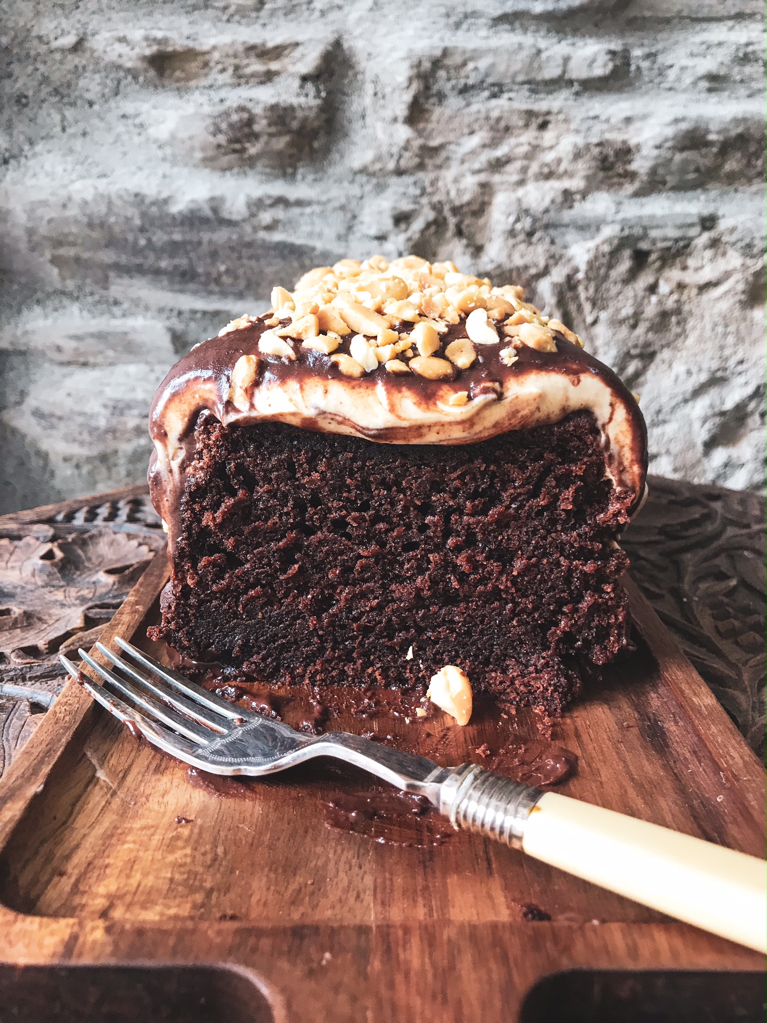 Chocolate peanut butter cake on a wooden plank.