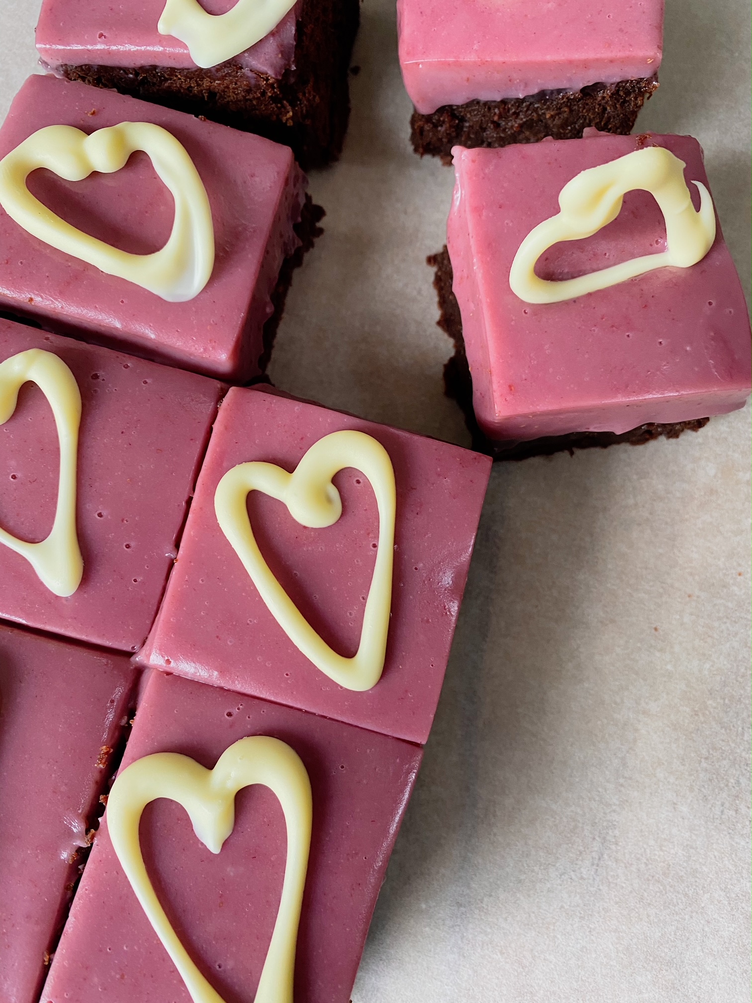 Top view of. White Chocolate Berry Ganache Brownies with white chocolate hearts.