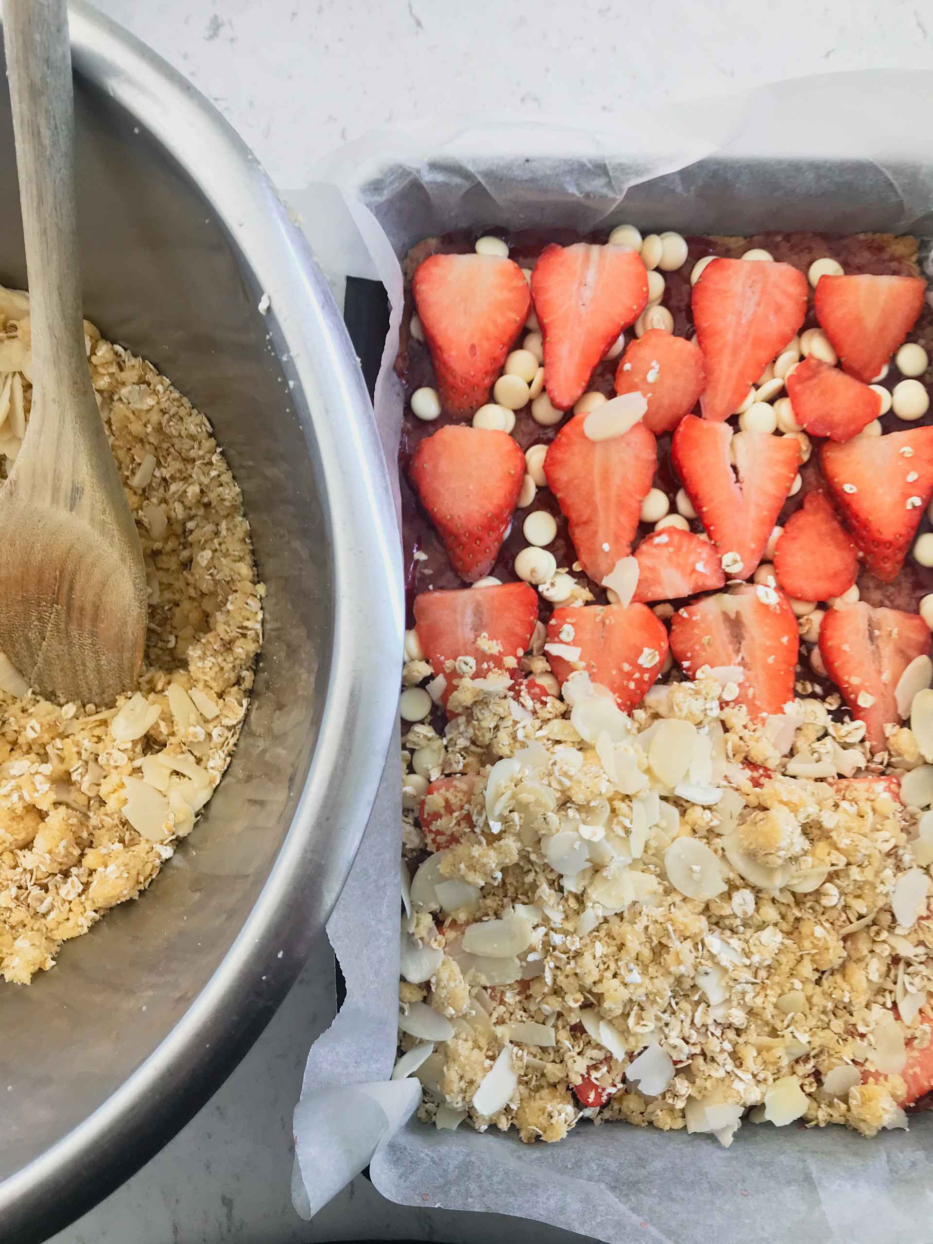 White chocolate and strawberries on a brownie in a cake pan.