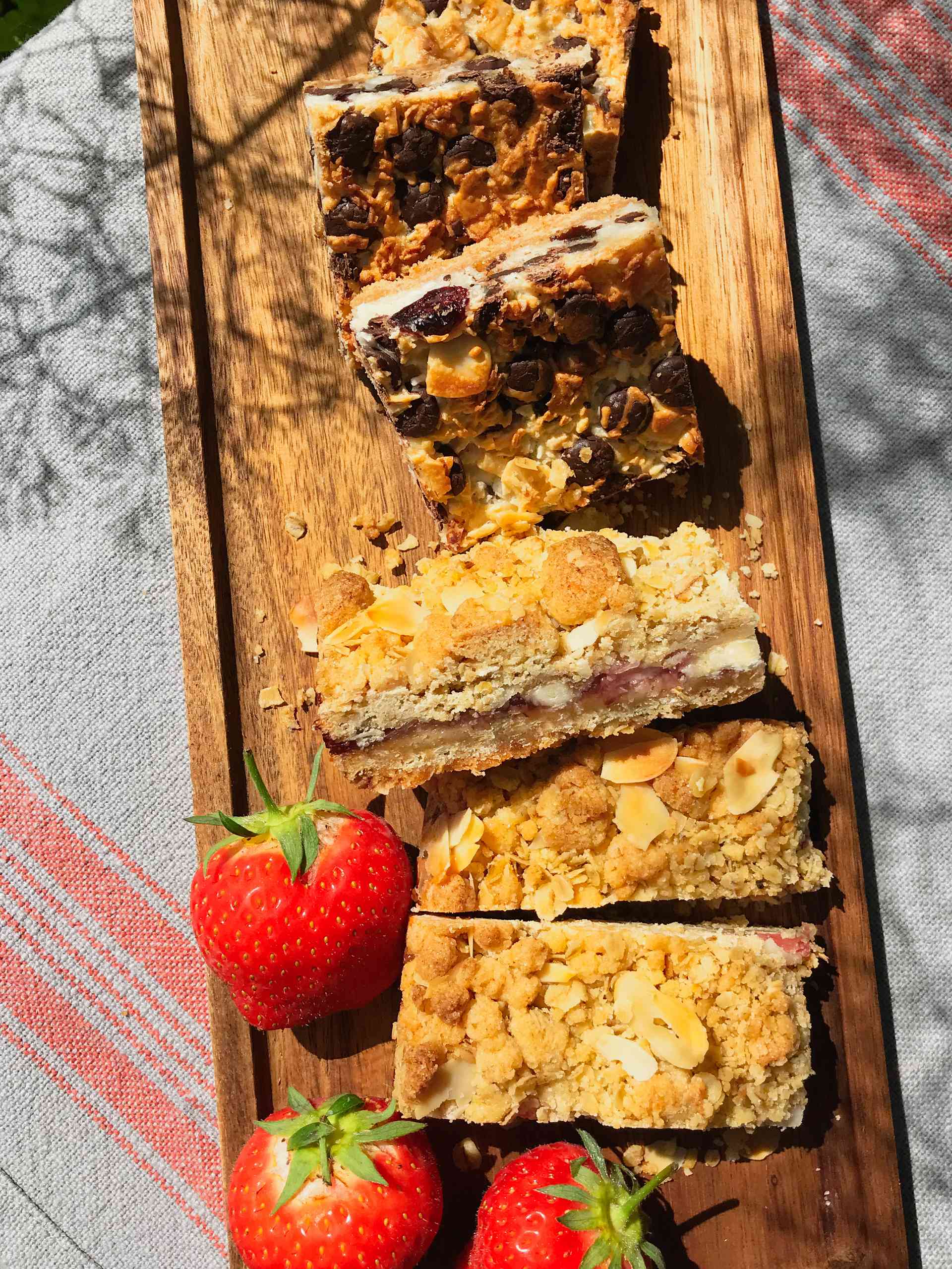 Strawberry and White Chocolate shortbread on a wooden plate with strawberries on the side.