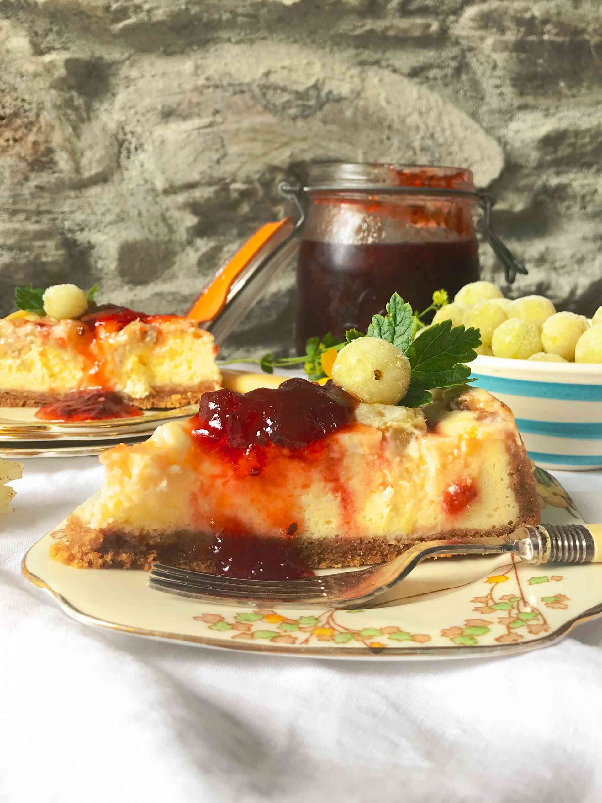 Two slices of Gooseberry and Ginger baked cheesecake on sideplates.
