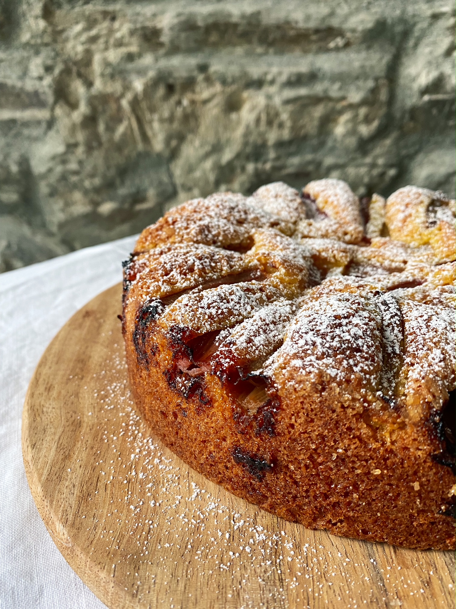Rhubarb, Orange and Almond Cake on a wooden plate.