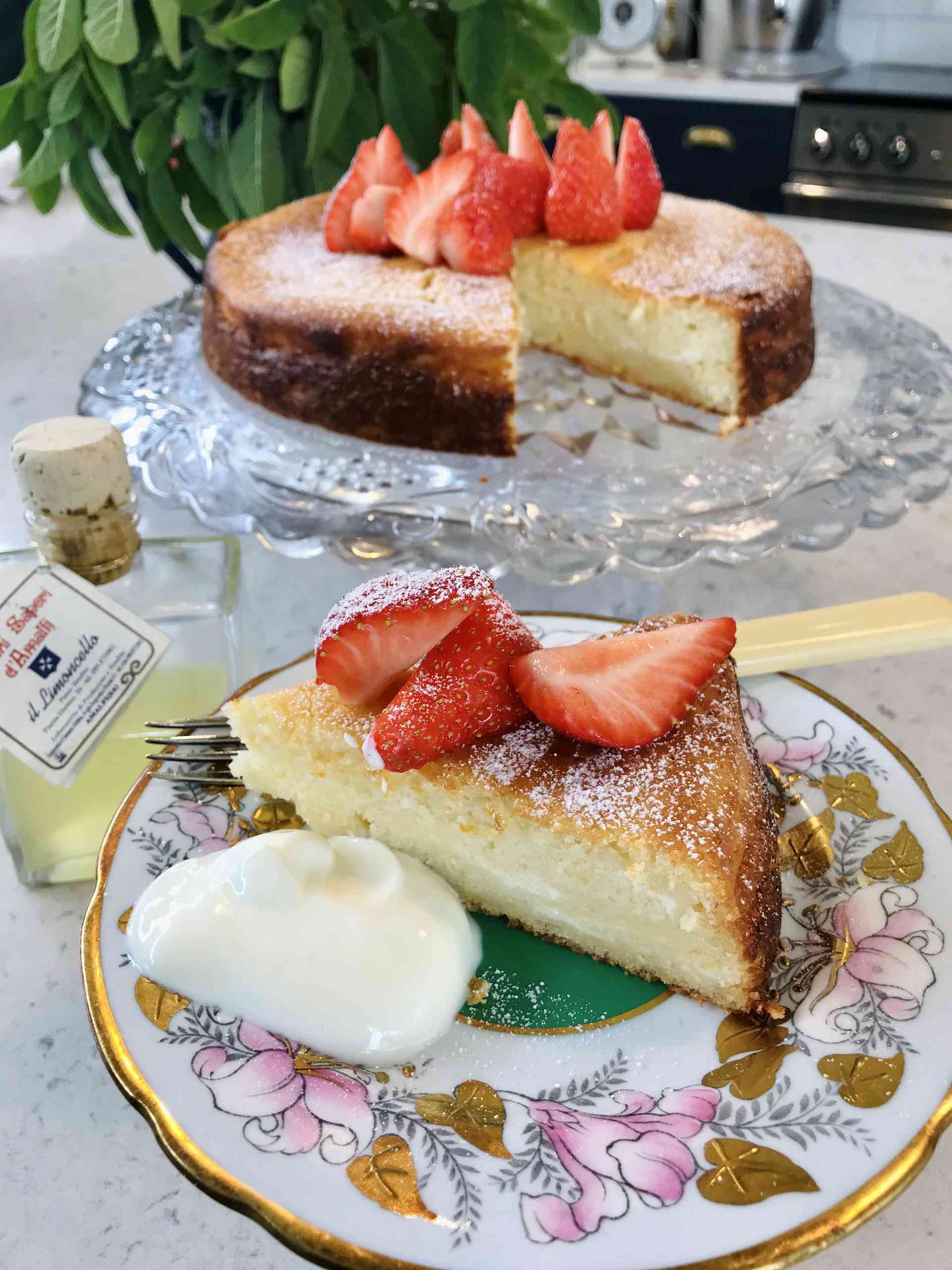 Limoncello Ricotta Cake with strawberries on a sideplate.
