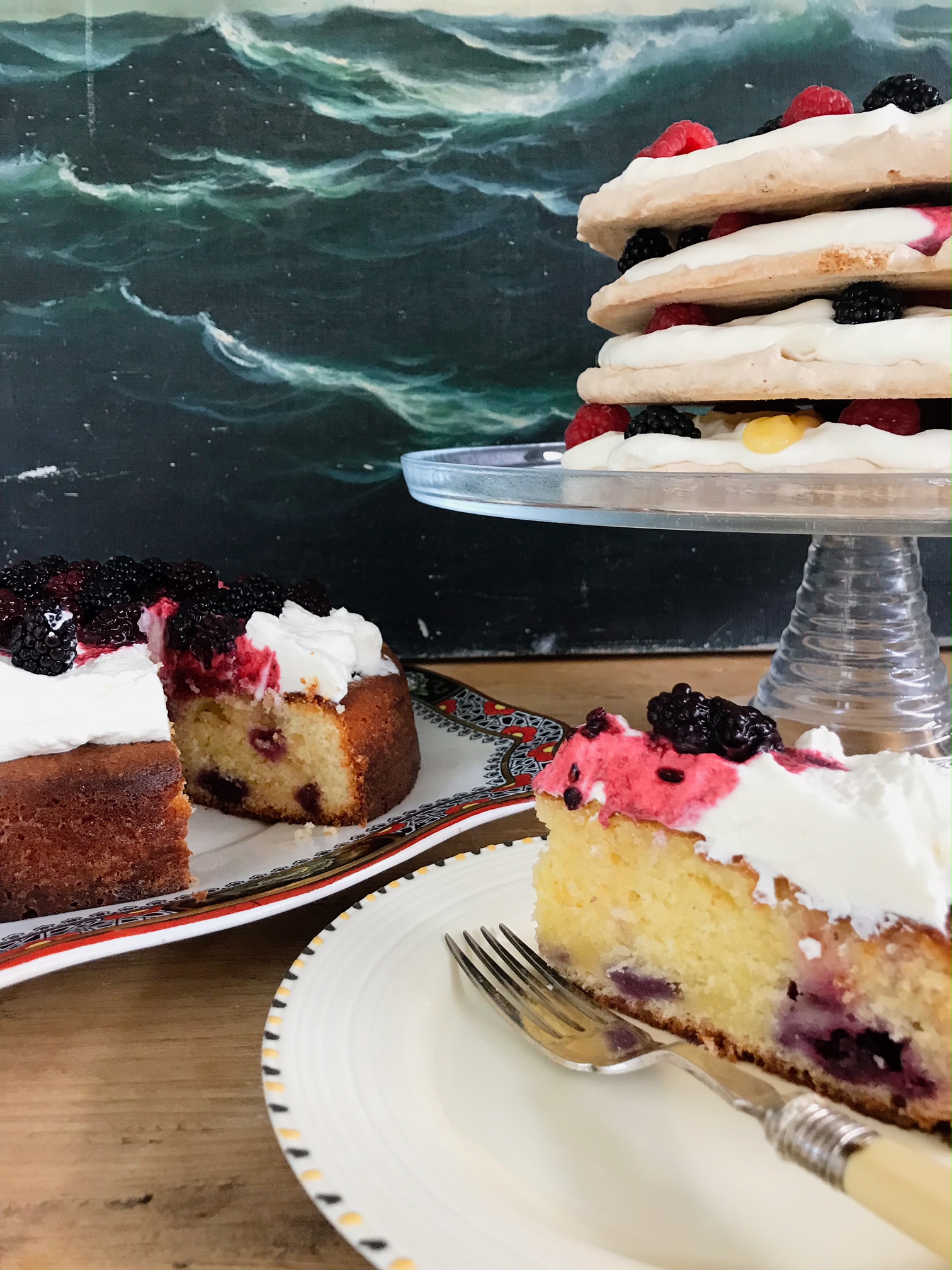 Blackberry cakes on a plate. and a slice on a sideplate.