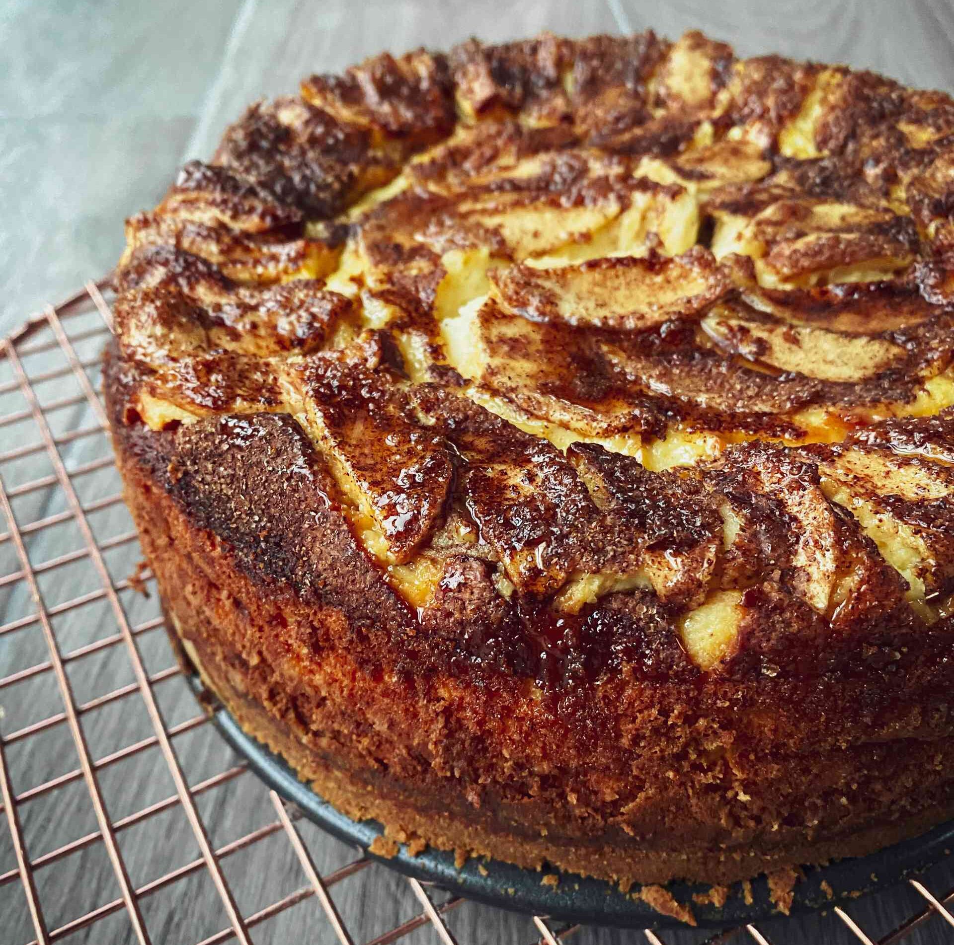 Apple, Cinnamon & Maple Syrup Baked Cheesecake on a rack.