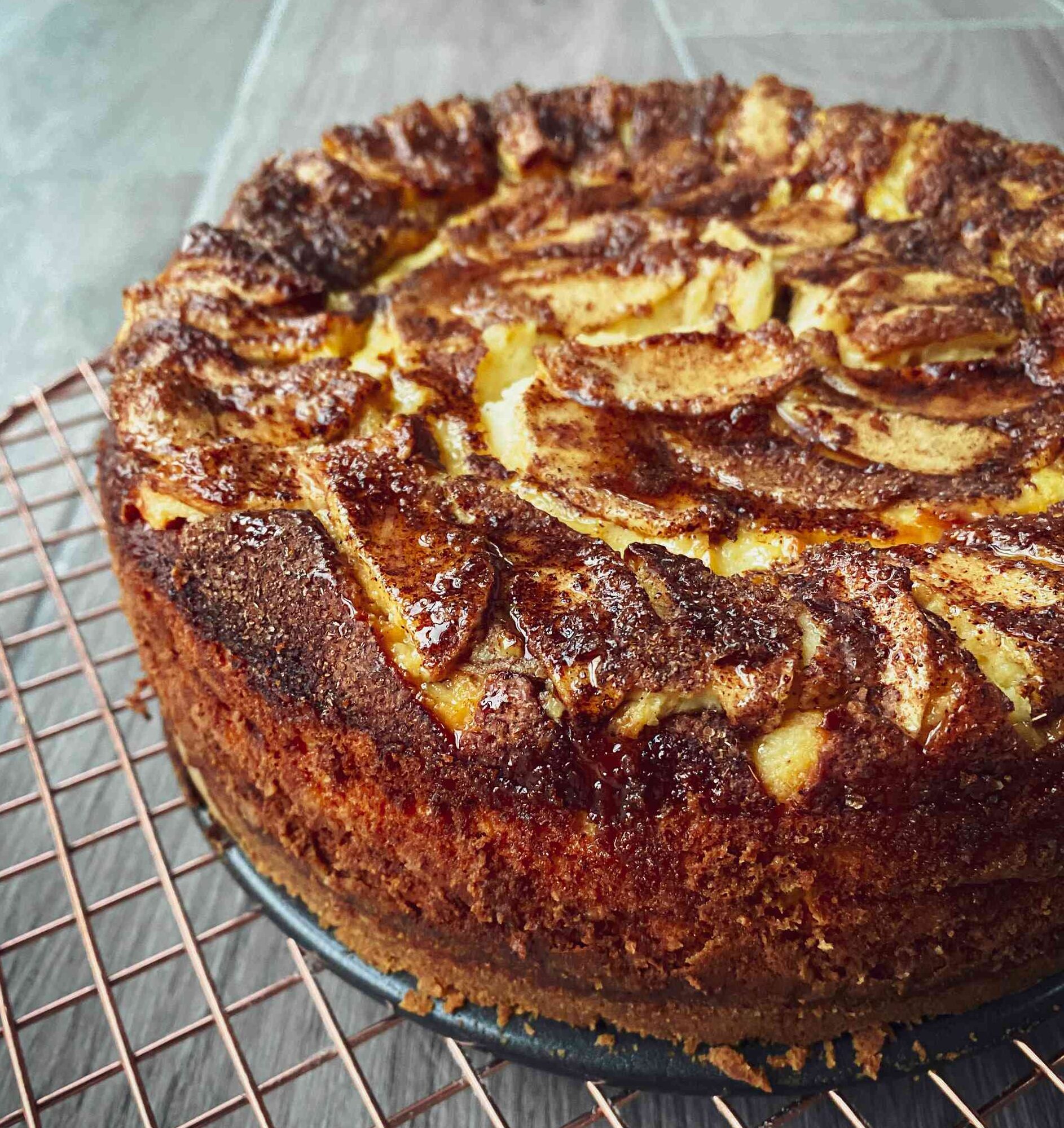 Apple, Cinnamon & Maple Syrup Baked Cheesecake on a rack.