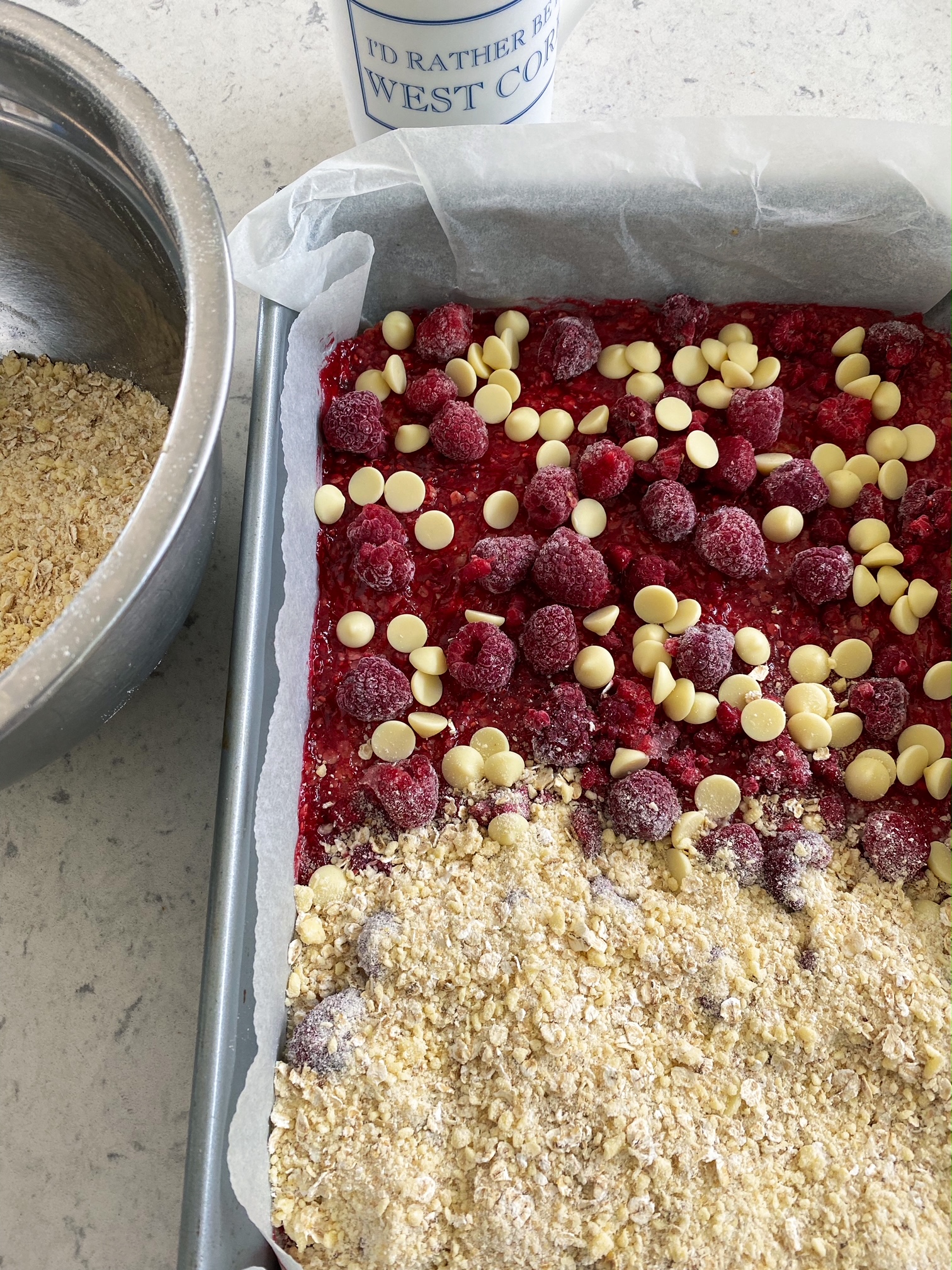 Raspberry and White Chocolate Crumble Bars in a cake tin.
