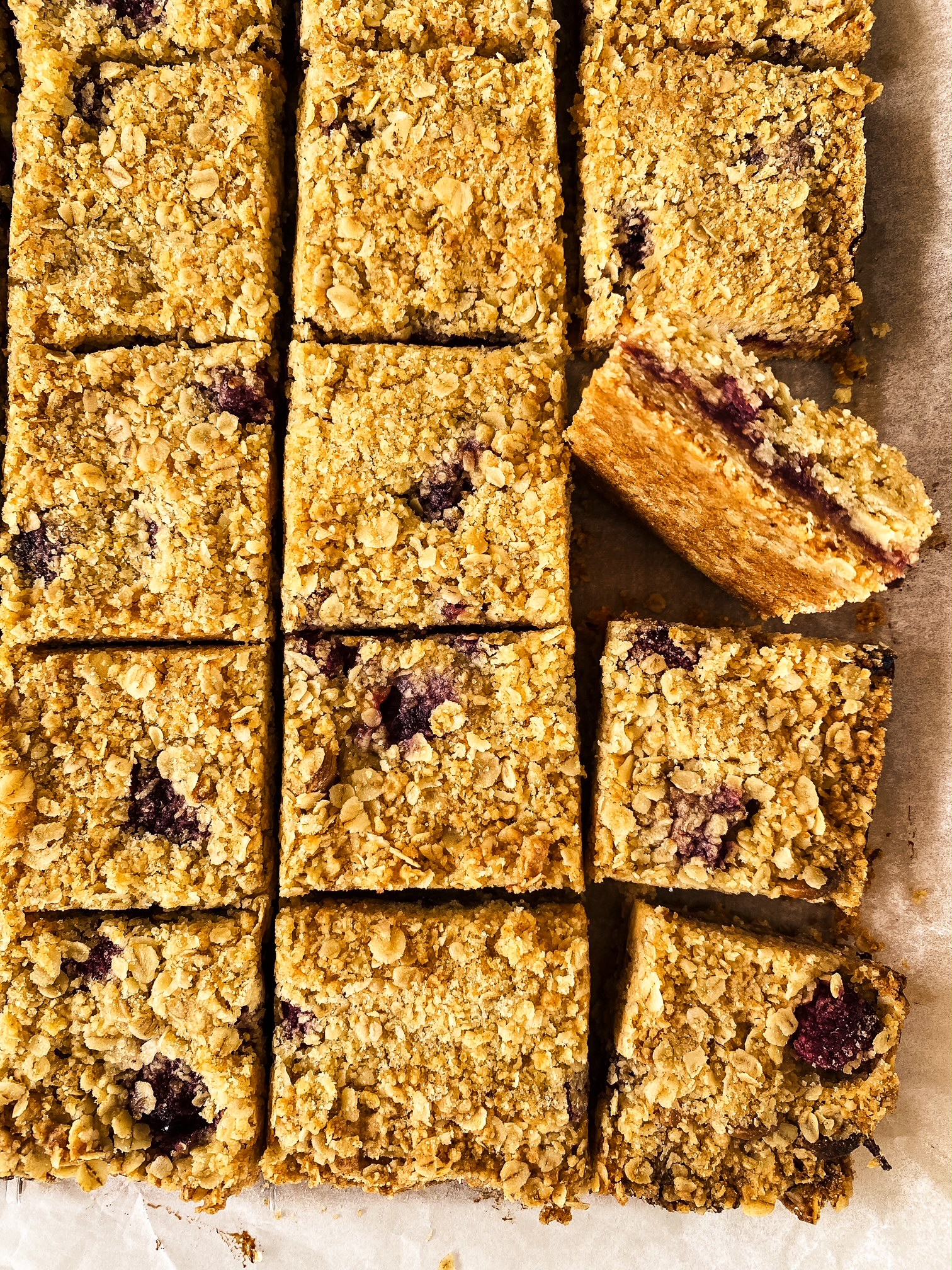 Raspberry and White Chocolate Crumble Bars on a table.