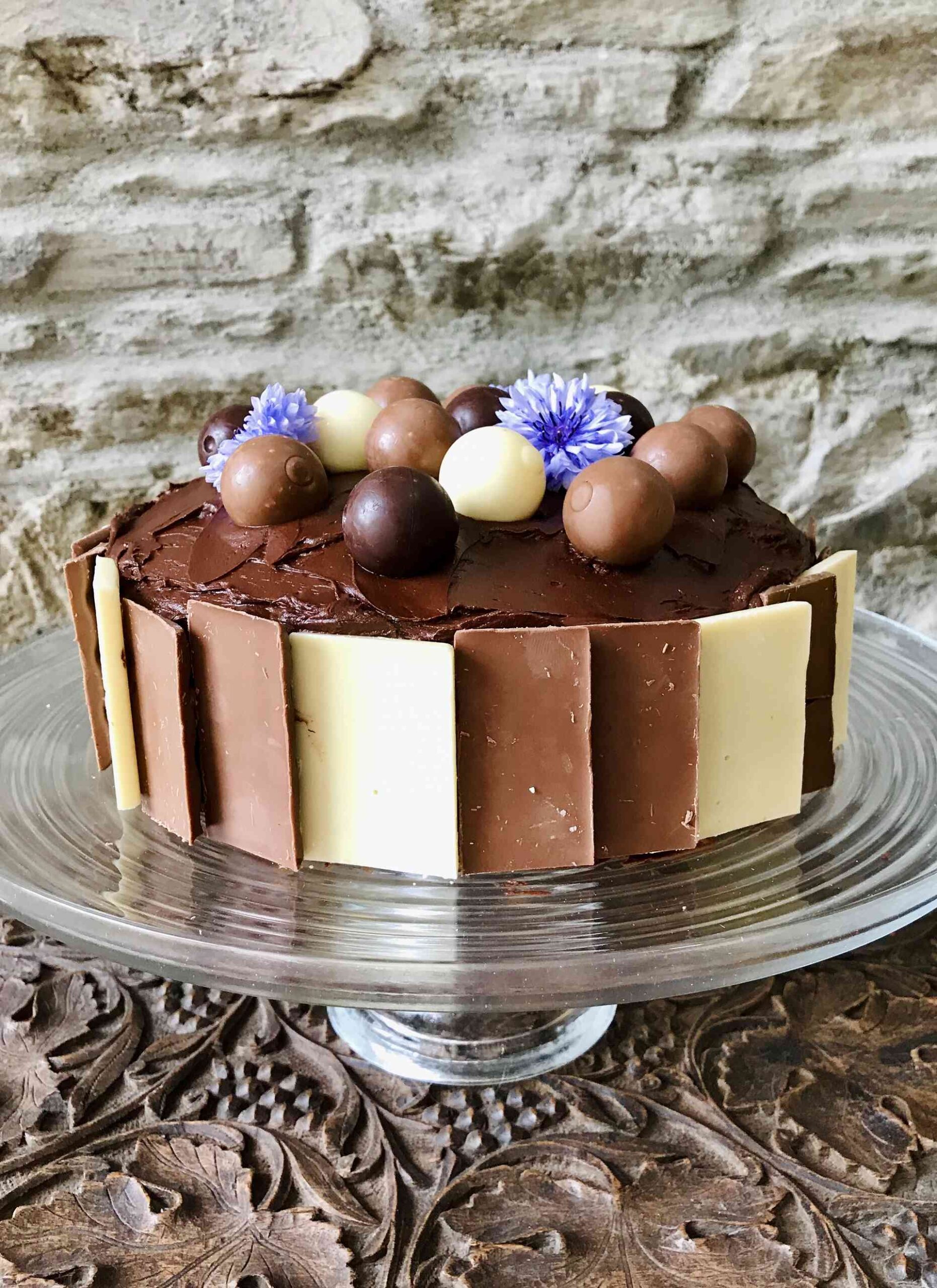 Ultimate chocolate cake on a glass plate.