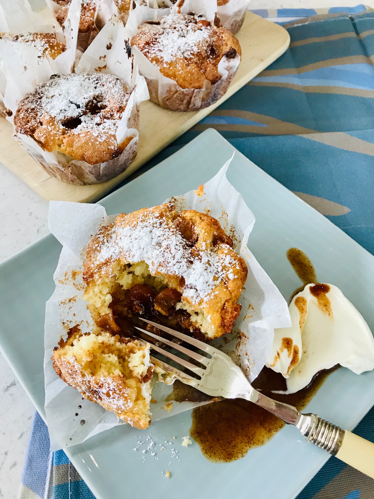 Toffee apple cinnamon muffin on a sideplate on a table.