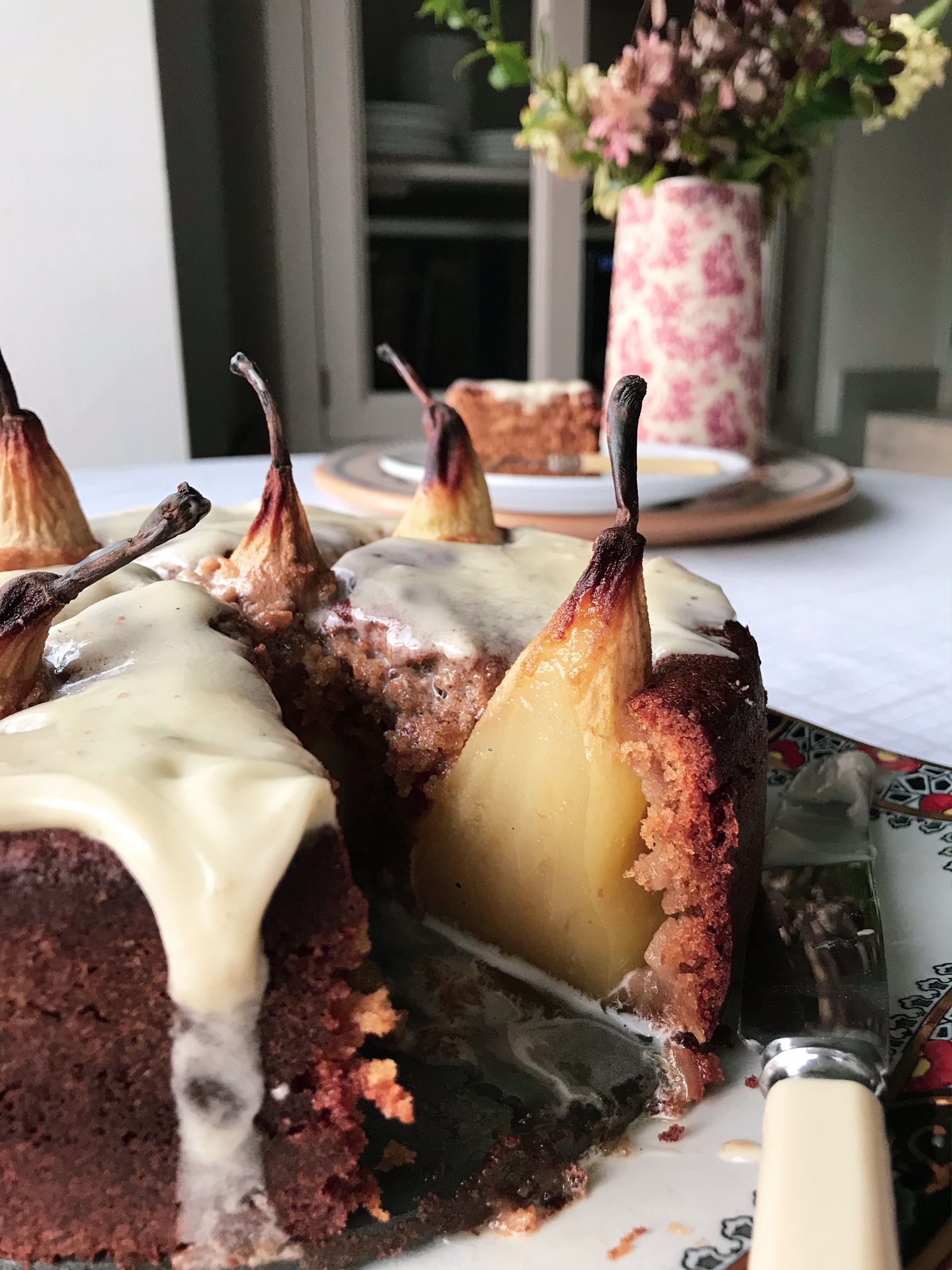 Pear, Ginger and Cardamon Cake on a plate cut open.