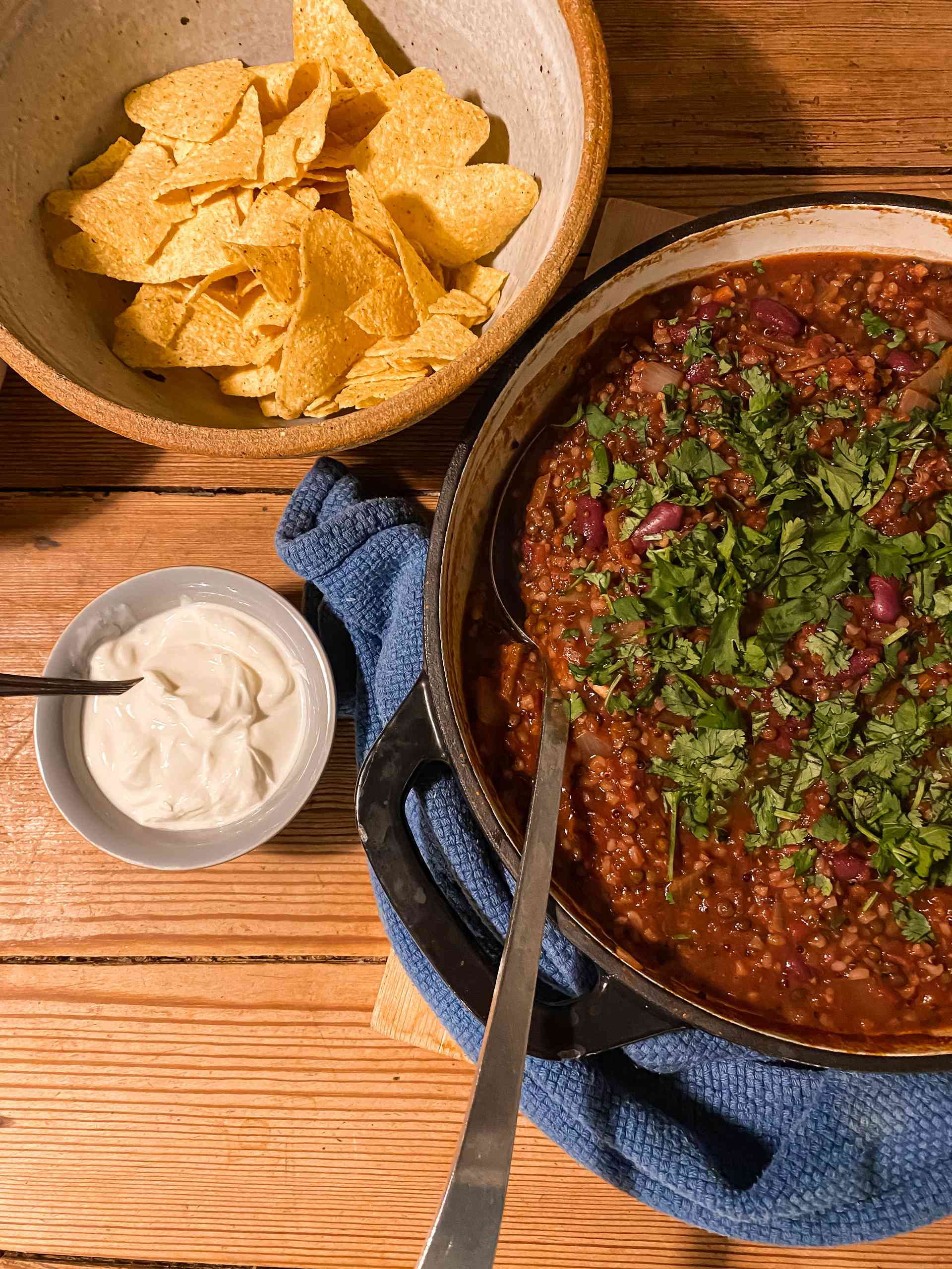 Vegetarian chili in a bowl with crisps on the side.