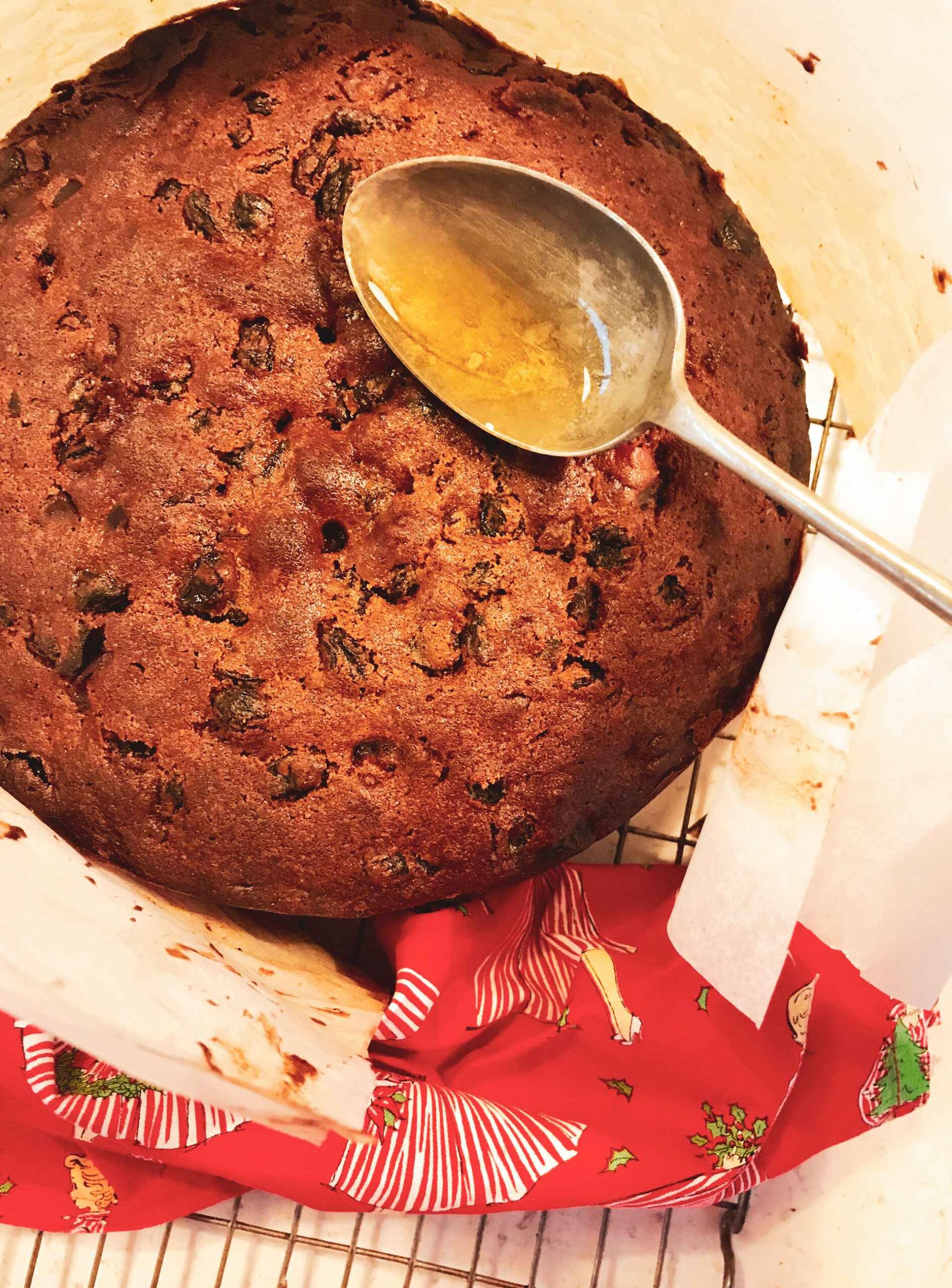 Christmas cake on a plate being glazed.