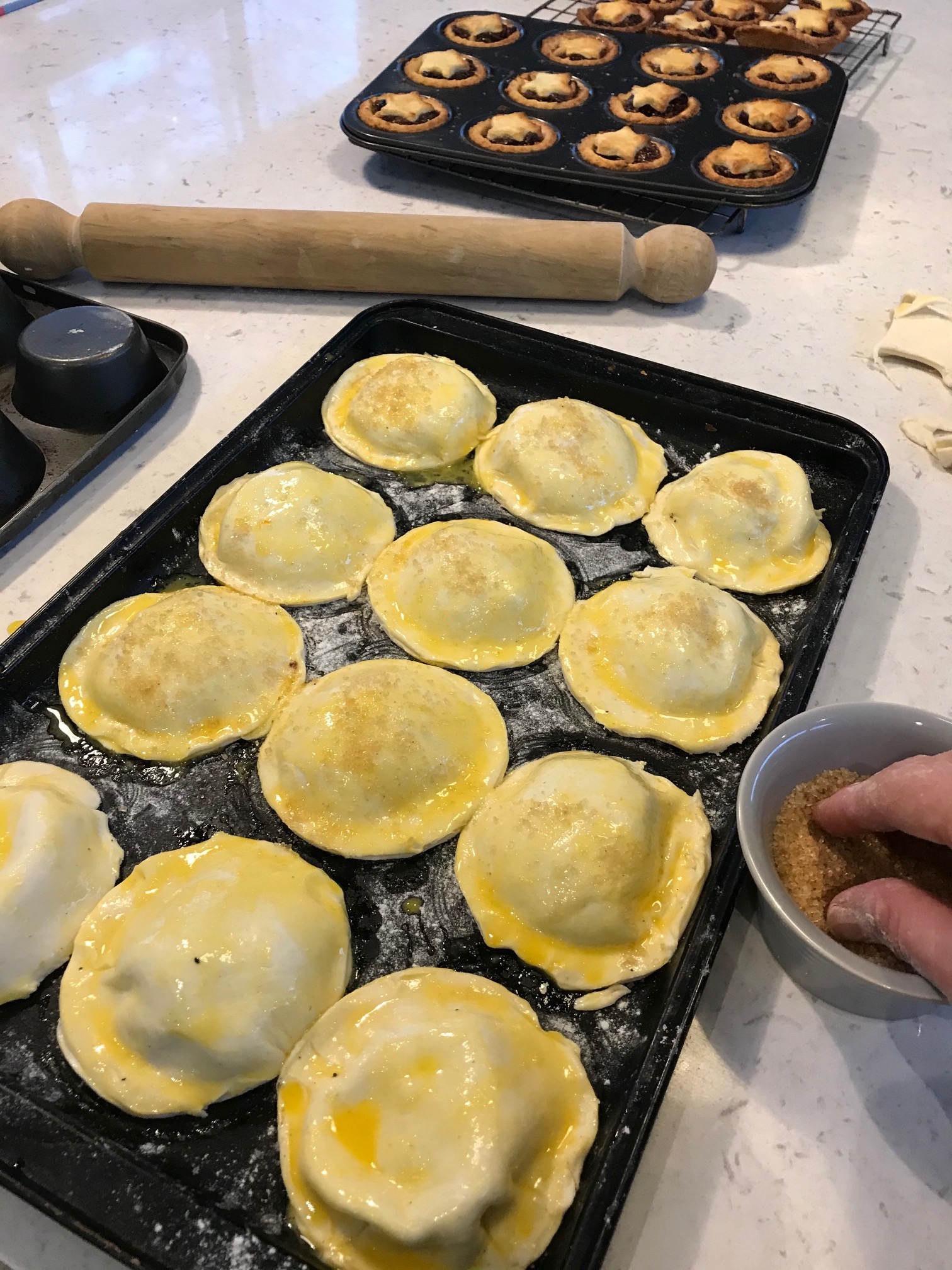 Mince pies in a muffin tin on a kitchen countertop.