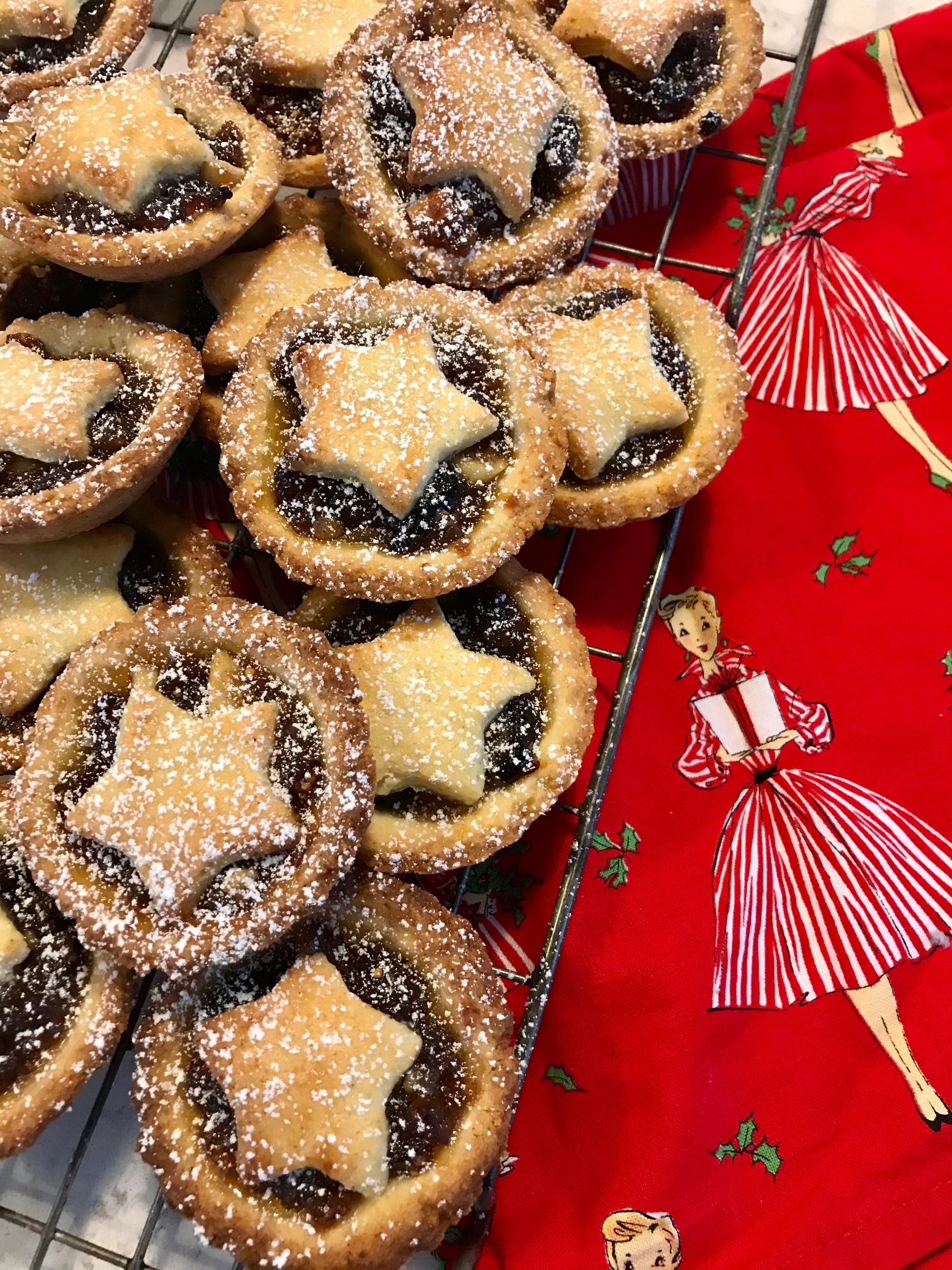 Mince pies on a rack on a kitchen countertop.