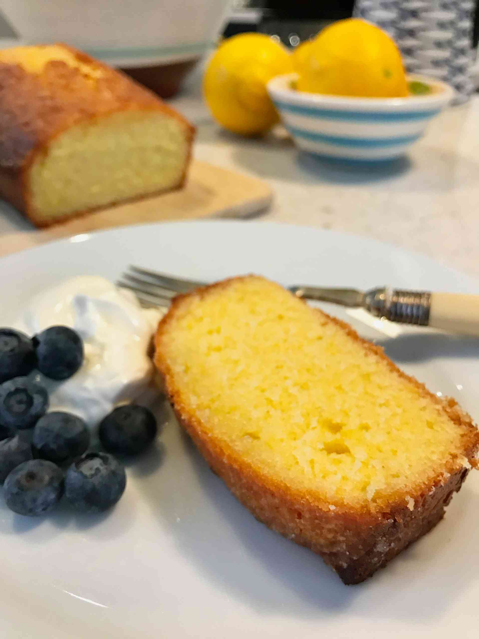 Lemon Drizzle cake with blueberries and whipped cream on the side.
