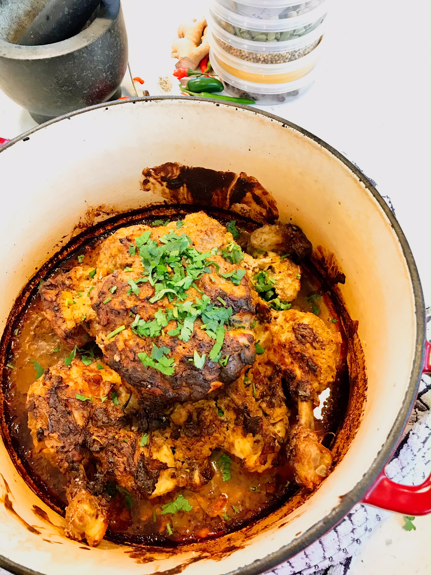 Curry with greens in a pan half empty on a kitchen countertop.
