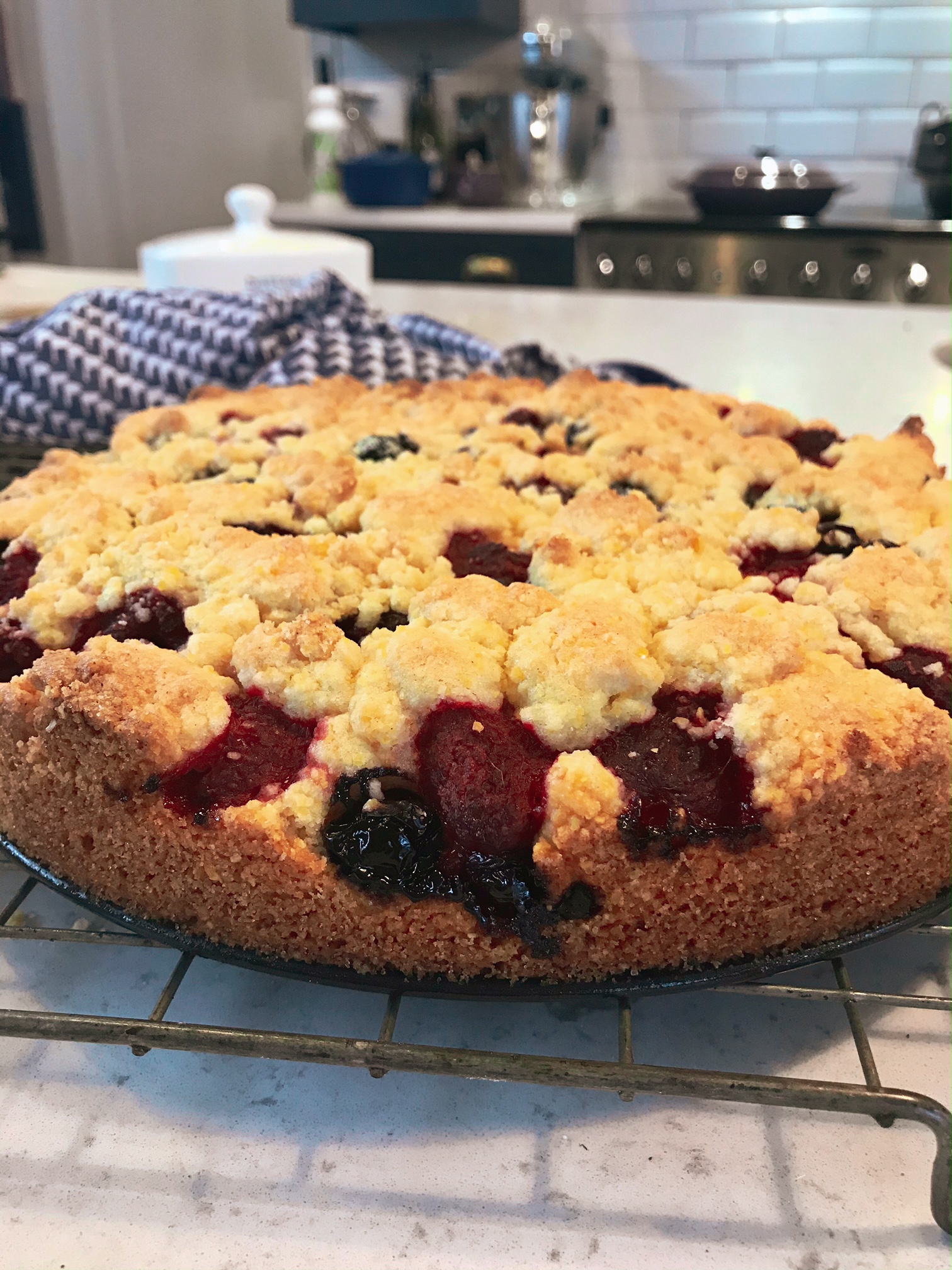 Berry Crunch Cake on a rack on a kitchen countertop.