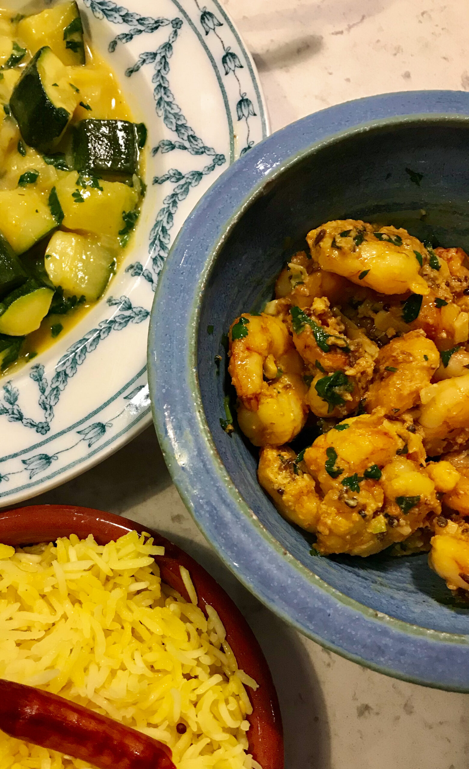 Kebabs, Curry and Cheese on plates on a kitchen countertop.