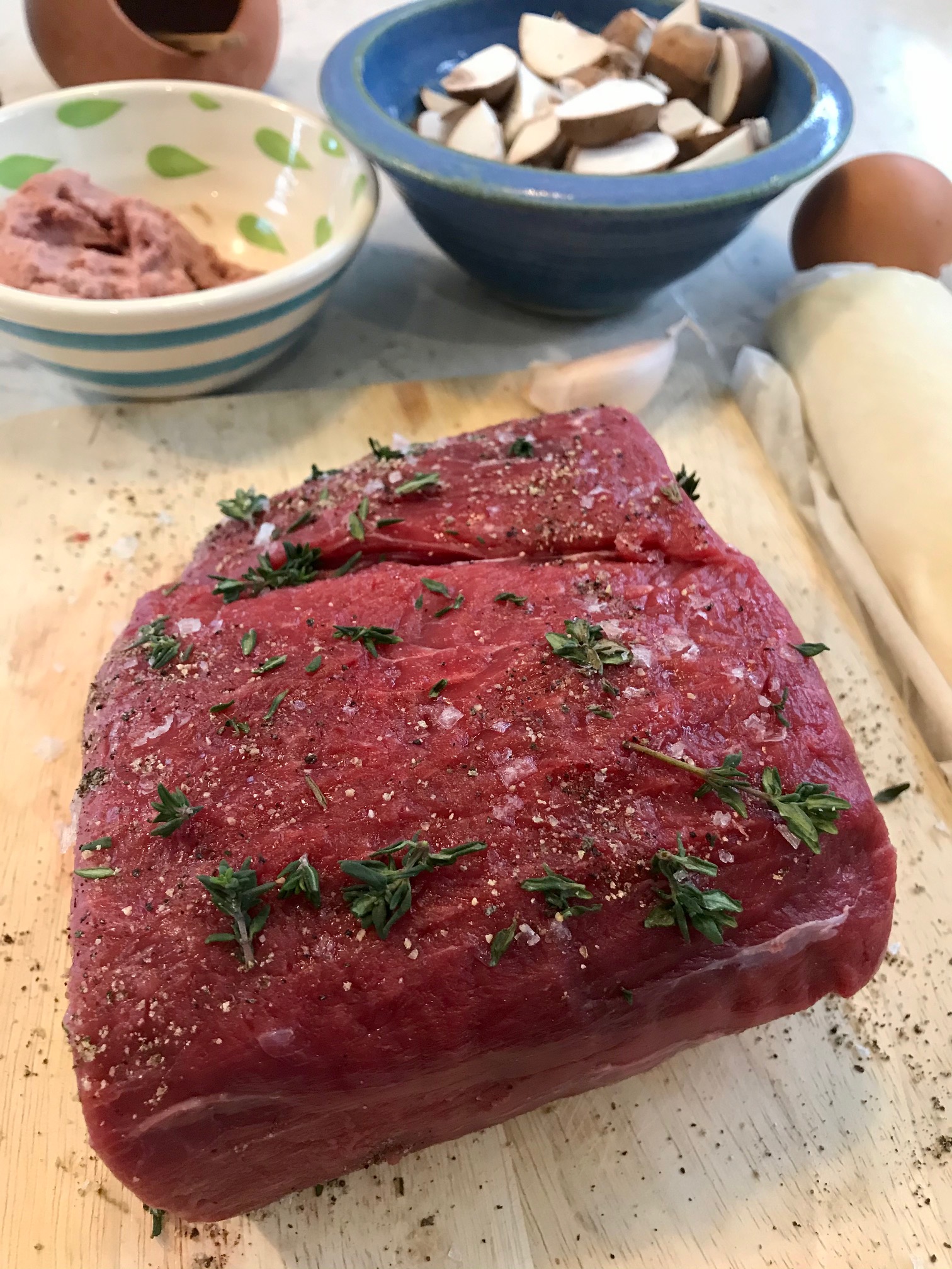 Beef wellington being made on a kitchen countertop.
