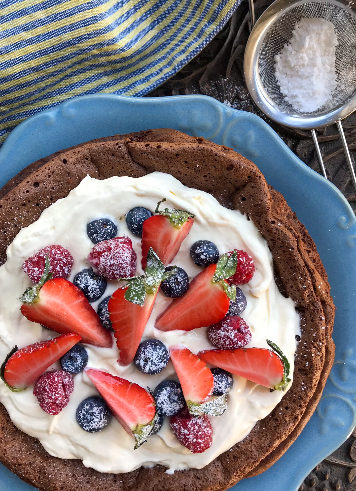 Flourless chocolate cake on a plate with flour next to it.