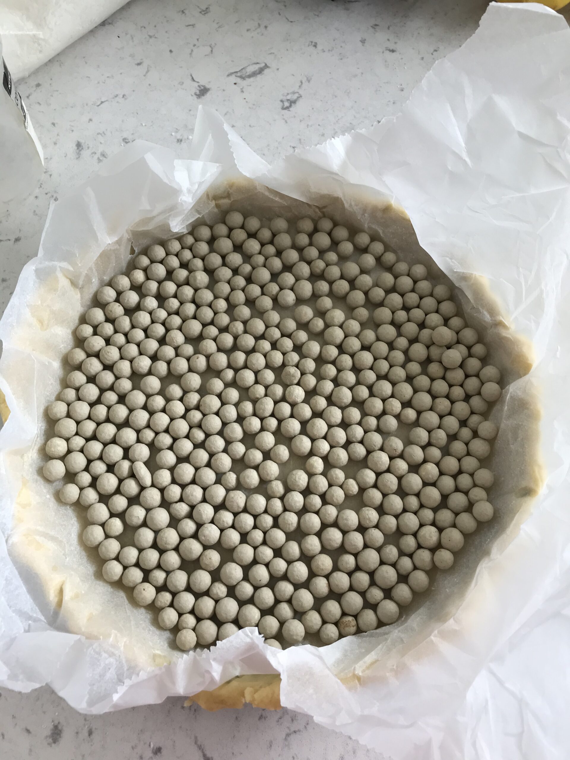 Dough balls in a cake pan on a kitchen countertop.